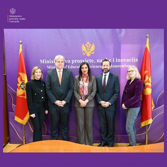 Gruppenbild mit fünf Menschen, dahinter zweimal die montenegrinische Flagge