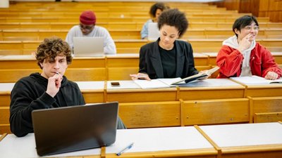 menschen im Hörsaal verteilt sitzend