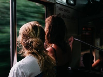 Zwei junge Frauen schauen aus dem Fenster in einem Zug