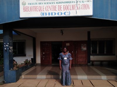 Young female student standing in front of university building