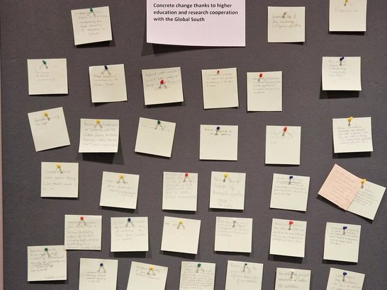 Various yellow post-its with writing pinned on a board