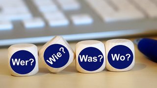 4 Würfel mit Aufschrift Wer, Was, Wie, Wo