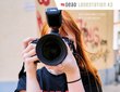  Girl holds a photo camera in front of her face