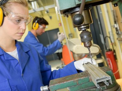 Young woman at a machine in production