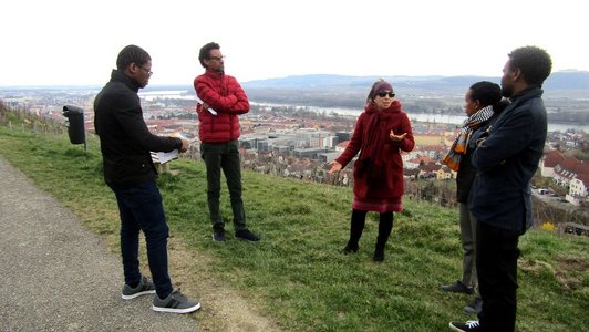 Five people standing on a path, overlooking a city
