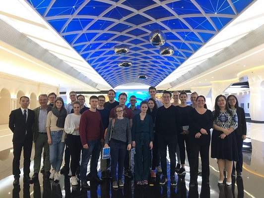 Group photo of many people standing in a room and looking into the camera