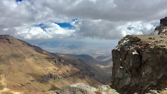 View from above on a mountainside under a cloudy sky