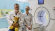 A man and a woman in a medical laboratory, next to an MRI.