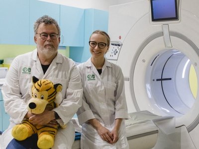 A man and a woman in a medical laboratory, next to an MRI.