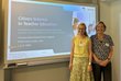zwei Frauen vor Präsentation auf Leinwand