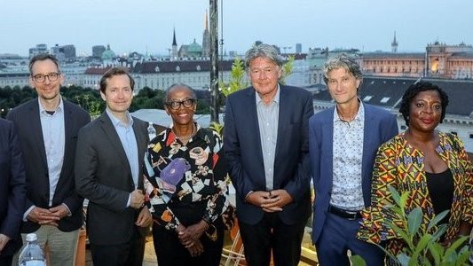 Ambassador Friedrich Stift (Managing Director of the ADA), Matthias Themel (ADA), Jakob Calice (Managing Director of the OeAD), Hannah Akuffo (APPEAR Advisory Board), Andreas Obrecht (OeAD), Leah Mwaisango Kalemela (APPEAR scholarship holder), Stella Asiimwe (moderator) , standing on a roof with the old town in the background.