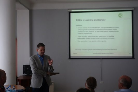Man standing in front of a presentation talking about something in front of a group