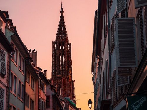 Eine Straße in Straßburg mit einer Kirche in der Dämmerung. 