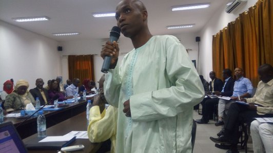 Man standing in front of a group of people and talking into a microphone