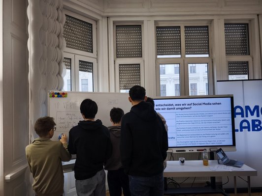 Schüler/innen schreiben auf Whiteboard