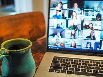 Bildschirm mit Teilnehmerinnen, Kaffeetasse daneben