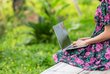 Girl wearing a floral dress sitting with her laptop