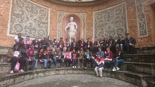 Gruppenbild Stipendat/innen im Halbkreis vor Statue 