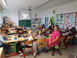 Foto aus dem Klassenzimmer der Gewinnerklasse. Lehrerin Roswitha Zeger sitzt gemeinsam mit den Kindern in der Klasse.