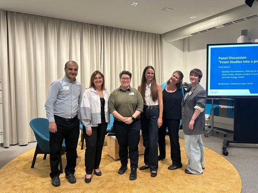 Photo of speakers, panellists and host standing next to each other