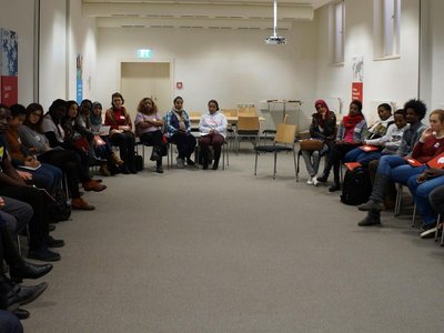 People sitting on chairs that are arranged in a U-shape