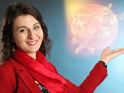 Female scientist holding her dissertation and pointing at a grafic in the background