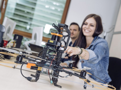 Foto einer Studierenden mit einem Roboter