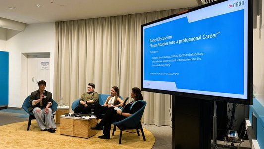 Panellists sitting on chairs and talking to each other