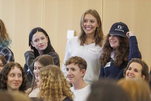 Mädchen und Jungs, die fröhlich in einem Saal stehen.