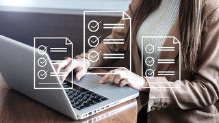 Frau am Laptop mit schwebenden Dokumenten