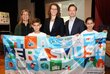 Die Bildungsministerin Mag. Dr. Iris Rauskala hält zusammen mit Jakob Calice zwei Kindern und einer weiteren Dame ein Erasmus Banner hoch.