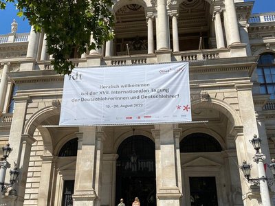  The main gate of the main building of the University of Vienna. There is a large banner that wishes you a happy International German Teacher Day.