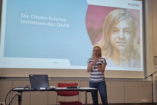 Petra Siegele beim Vortrag vor Leinwand mit Präsentation