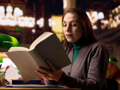 Mature female student in a work room surrounded by books and documents