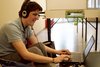 Bursche mit Kopfhörern vor einem Laptop