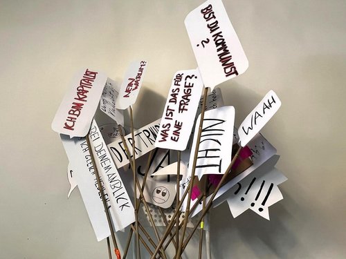 Beschriebene Papierstücke, die an Stäbchen geklebt wurden