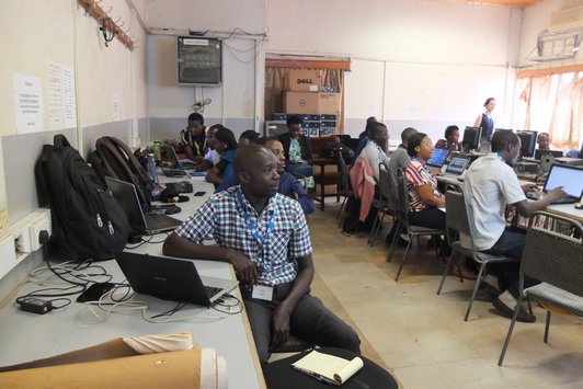 Group of people sitting at workingplaces with notebooks