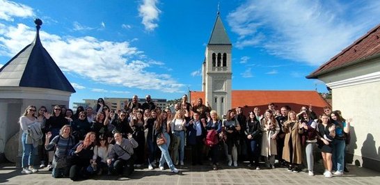 Ein Gruppenbild auf einem Platz vor einer Kirche