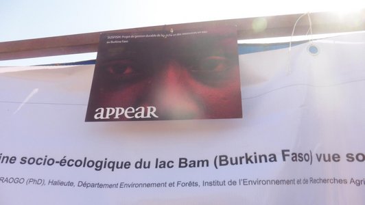 Red APPEAR poster hanging in front of another big white poster