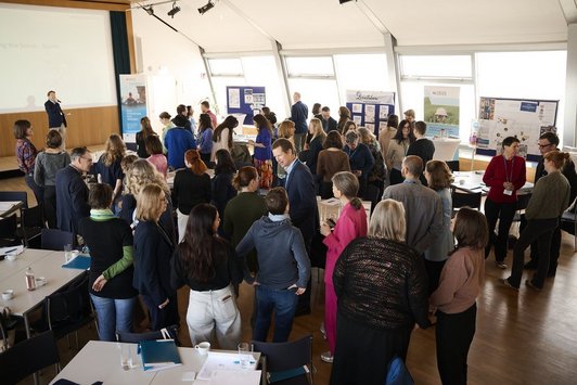 Zahlreiche Personen stehend in angeregtem Gespräch