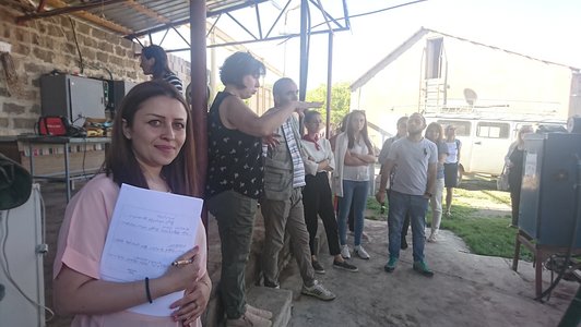 Group of people standing together and one woman looking into the camera