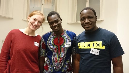 One woman and two men laughing into the camera