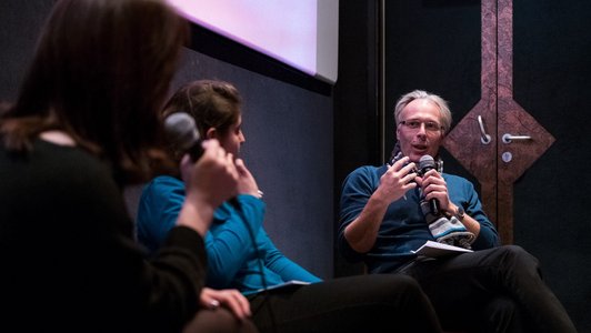 two panellists and the moderator of the film days sitting in the cinema and discussing about the movie's topics