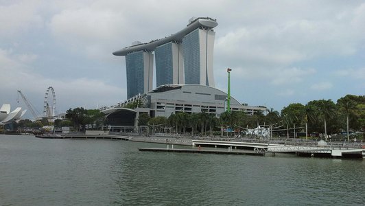 A huge building in Kuala Lumpur with a river in front of it.