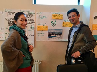 Two scholars in front of flip chart presenting their work