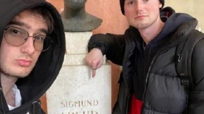 Zwei junge Männer, in der Mitte eine Büste von Sigmund Freud
