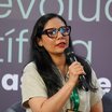 Eine Frau spricht ins Mikrofon, Podiumsdiskussion oder ähnliches