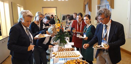 Ein großer Buffettisch mit Gästen, die sich an den Speisen bedienen.