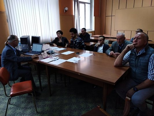 Group of people sittin at a table looking at a presentation