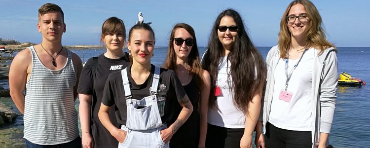 Eine Gruppe von Lehrlingen steht vor dem Meer